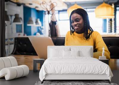 African american woman use laptop browse in internet in a cafe Wall mural